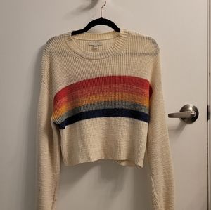 Cream-coloured sweater with multi-coloured stripes.